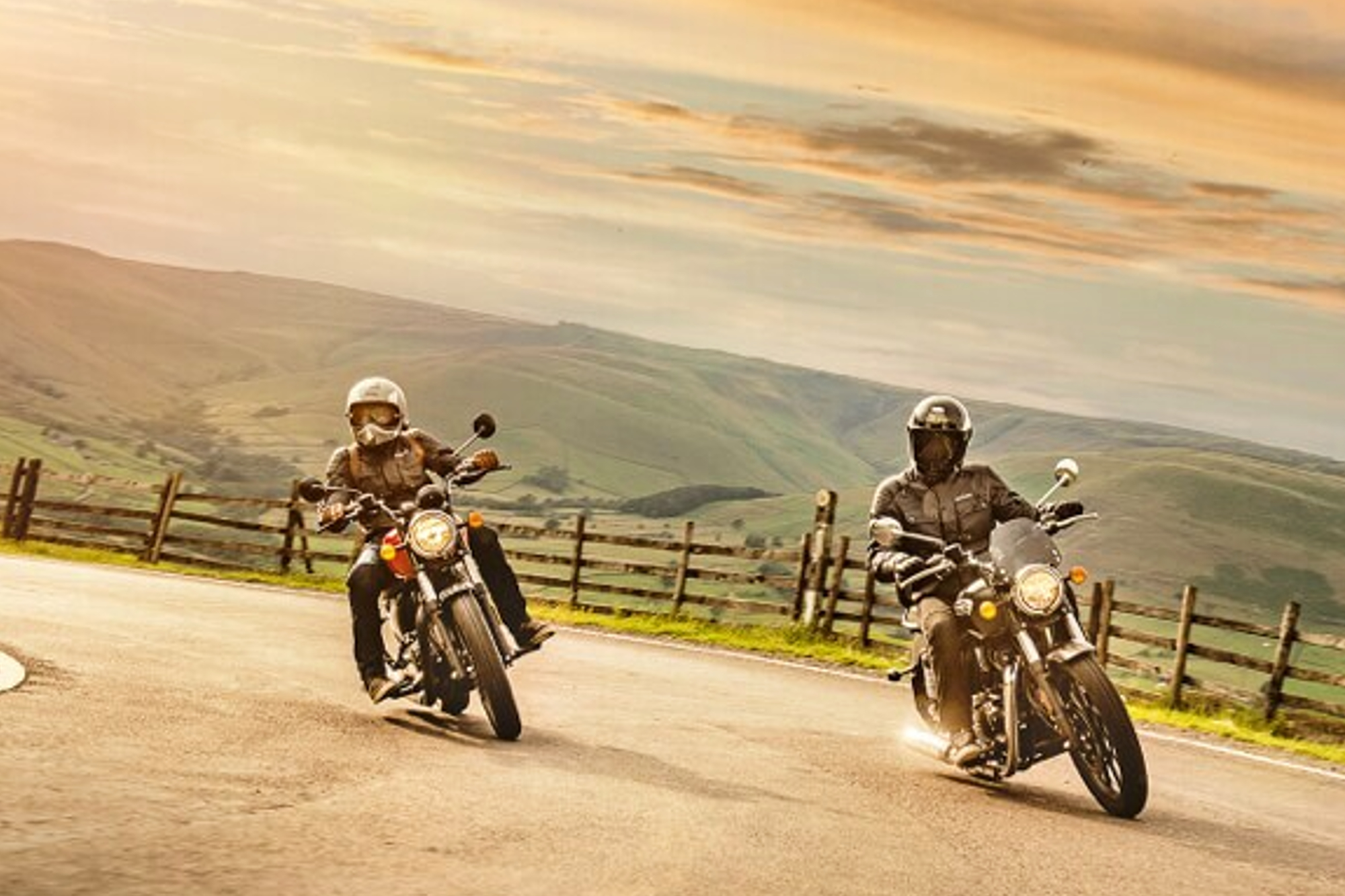 Two Royal Enfield Meteor coming off a corner on a roadway.