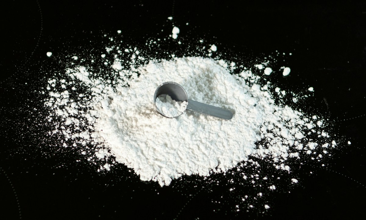 Spilled creatine with a scoop spoon