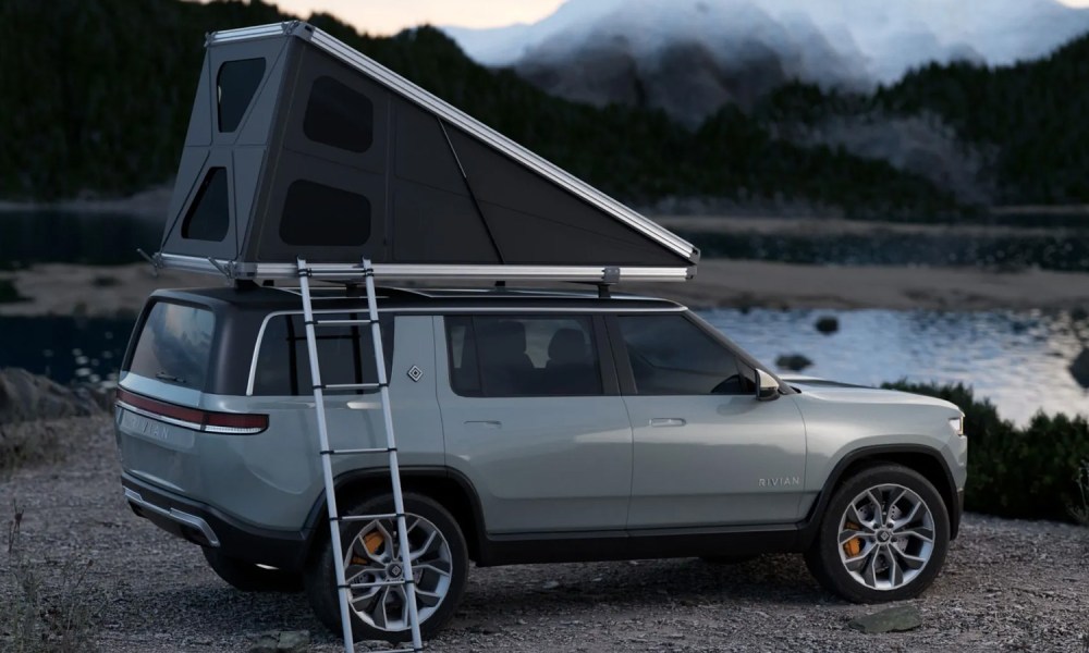 Hardsider HardTent rooftop tent mounted atop a silver SUV parked by a lake.