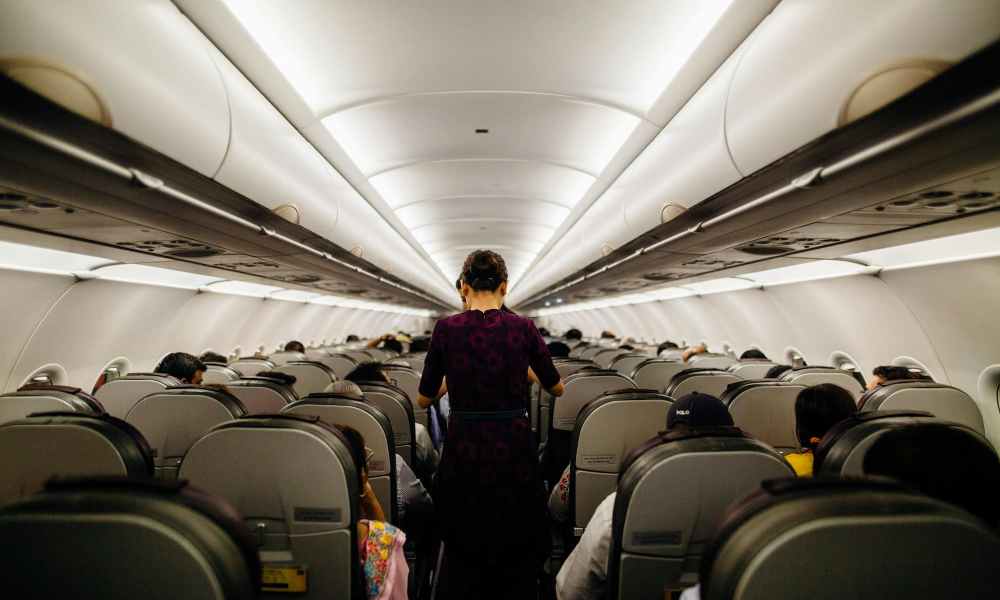 person walking down aisle in airplane