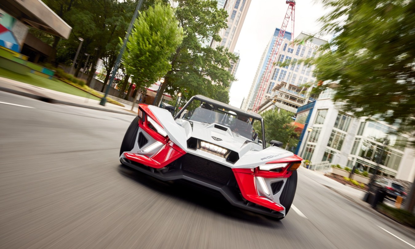 2024 Polaris Slingshot ROUSH edition driving through city at high speeds.