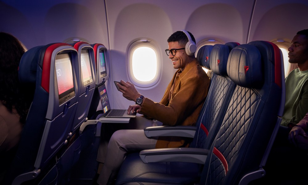 Delta passenger using free wi-fi at window seat