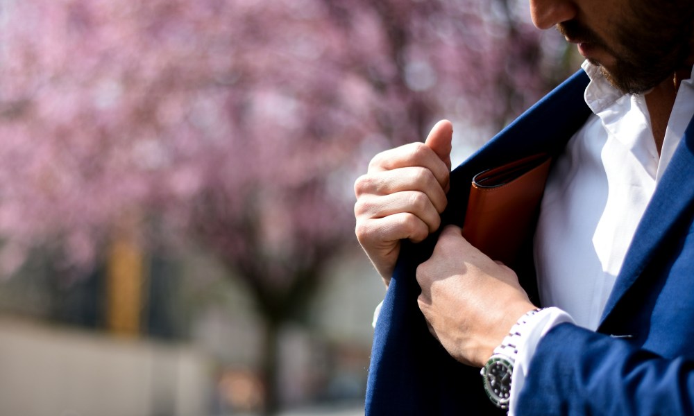 Man putting wallet in inside pocket of suit