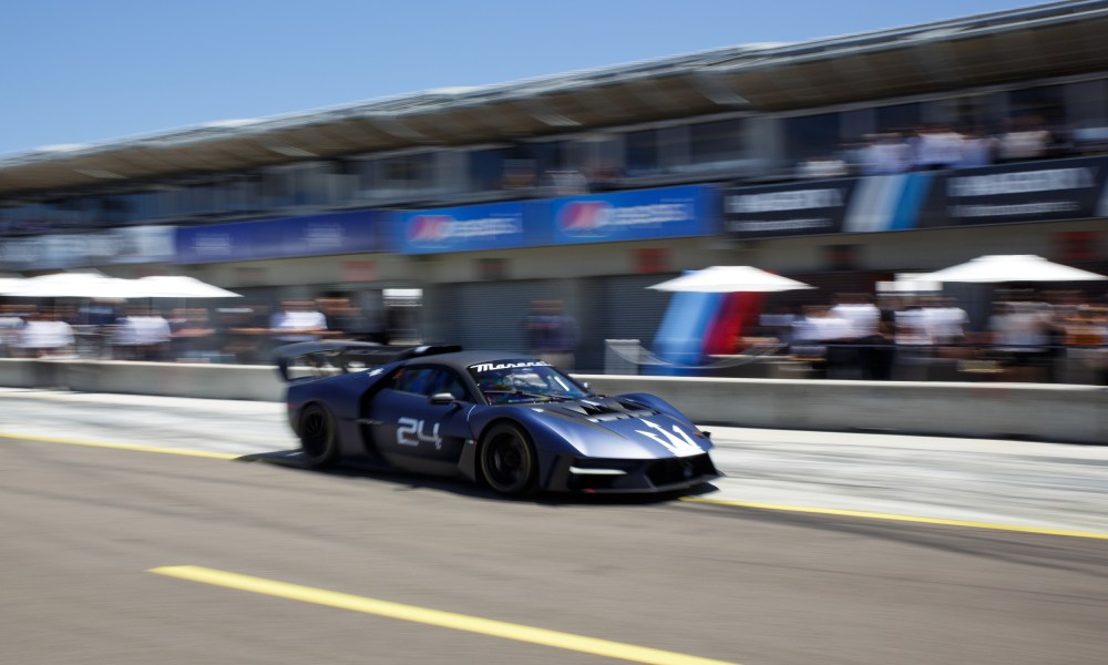 Maserati MCXtrema on the race track passing the Maserati garage at Leguna Seca during Monterey Car Week.