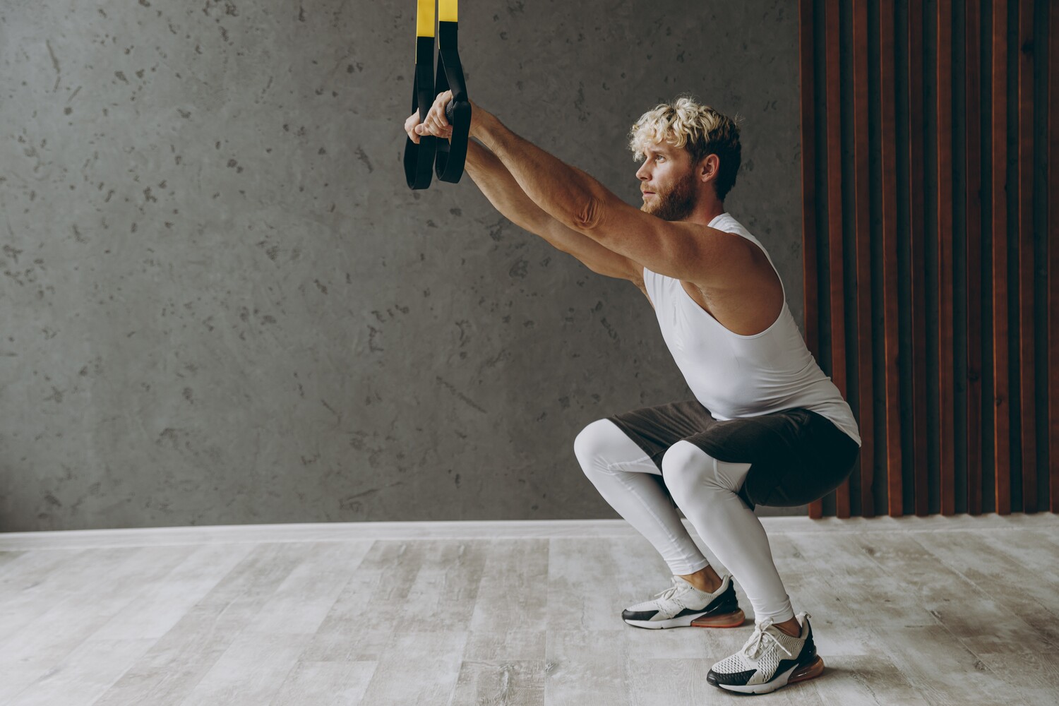 Man doing TRX squats.