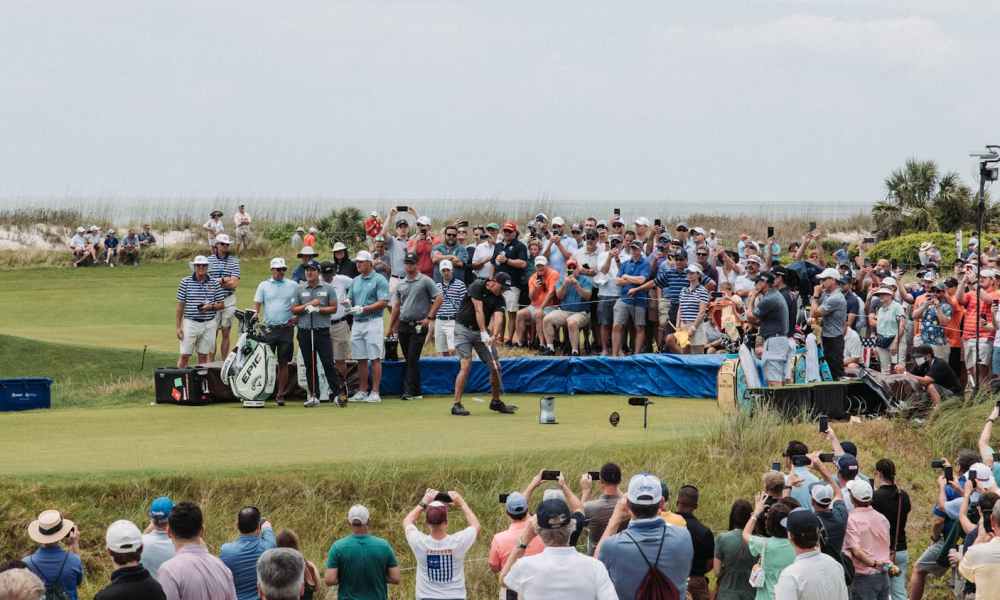 A crowd watching a golf tournament.