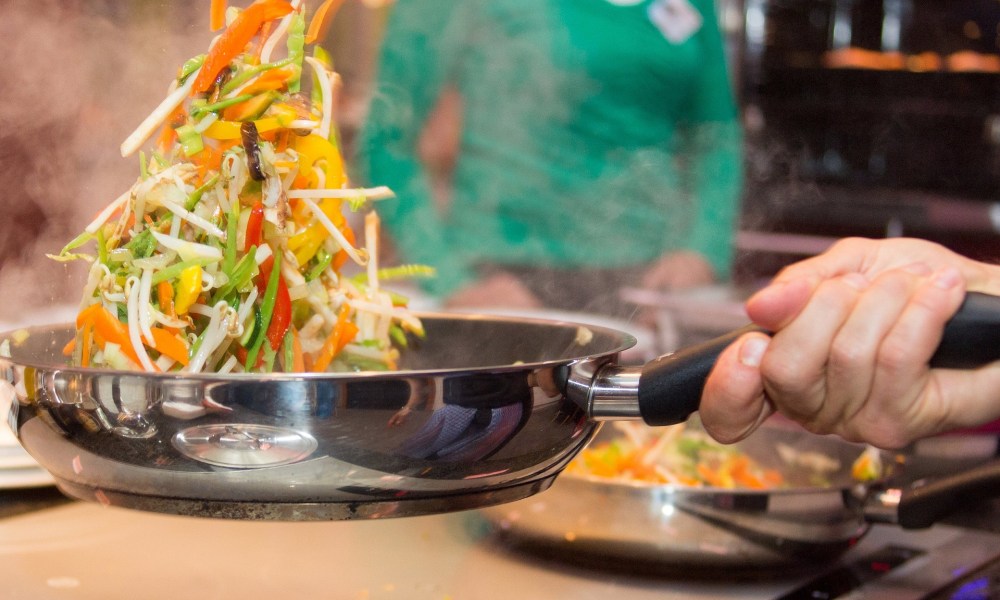 Vegetables being tossed in pan