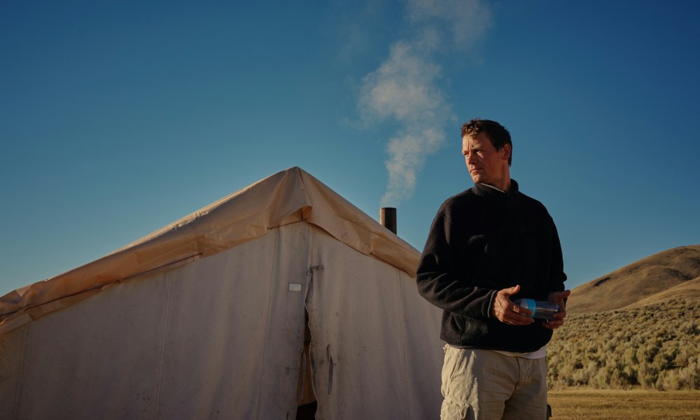 man standing outside of tent