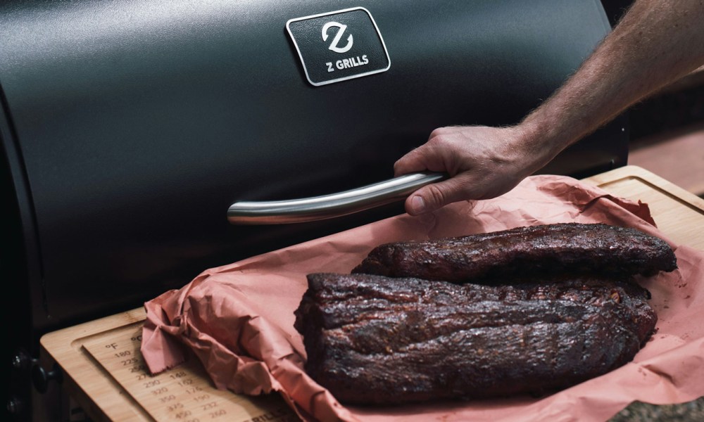 Closeup of meat in front of a pellet grill.