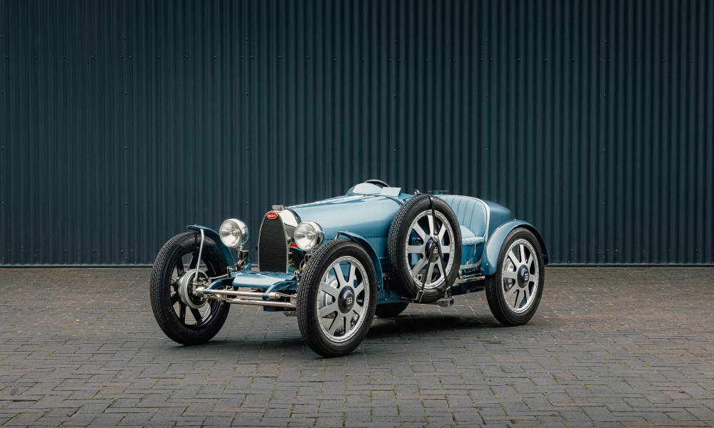 BUGATTI Baby II Tourbillon Edition parked on a stone-paved surface left front three-quarter view.