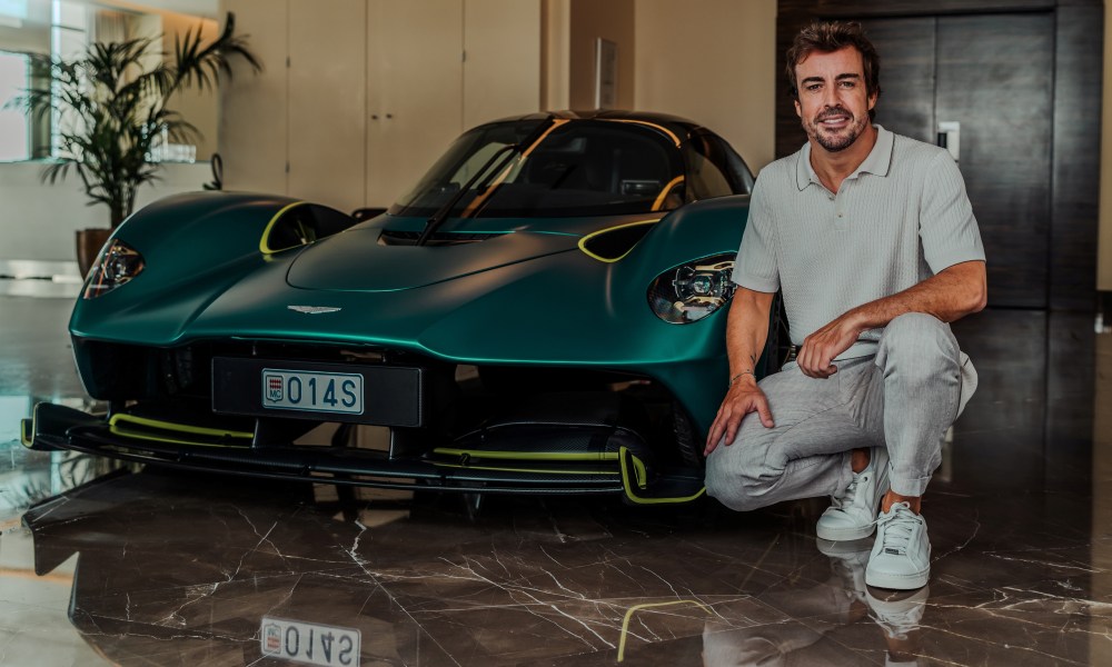 F1 driver Fernando Alonso's personal Aston Martin Valkyrie, front view with Alonzo squatted next to the car.