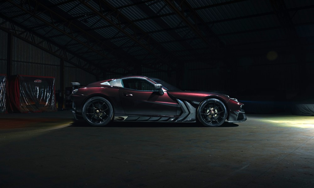 Ginetta Akula supercar for the road driver parked in a dark warehouse right profile.