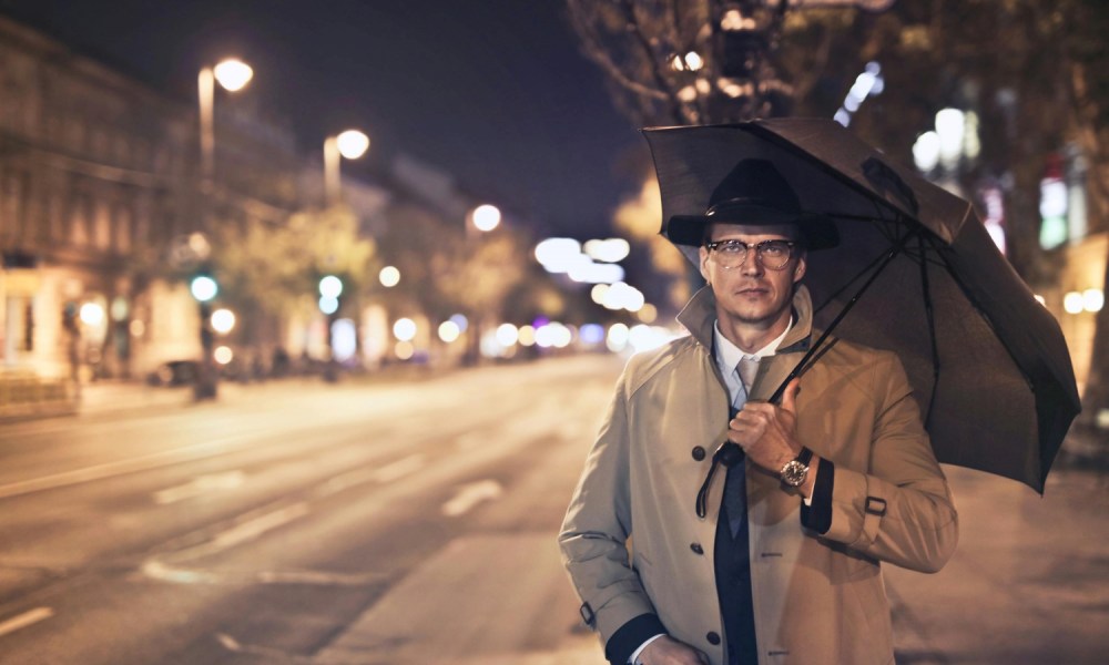 Man in trench coat with umbrella