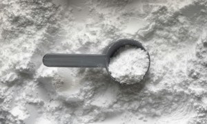 Creatine in a spoon on top of spilled creatine