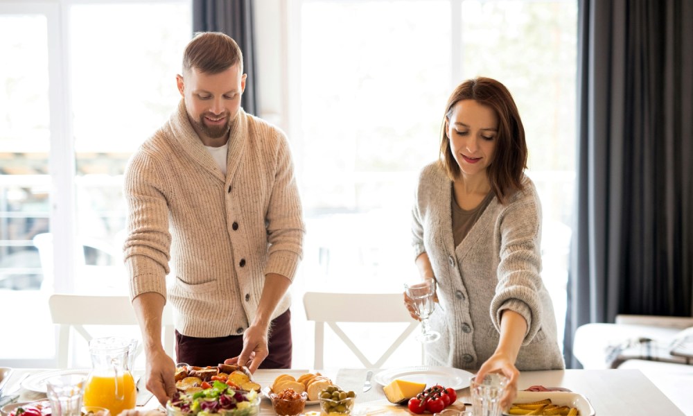 Man setting the table in a cardigan