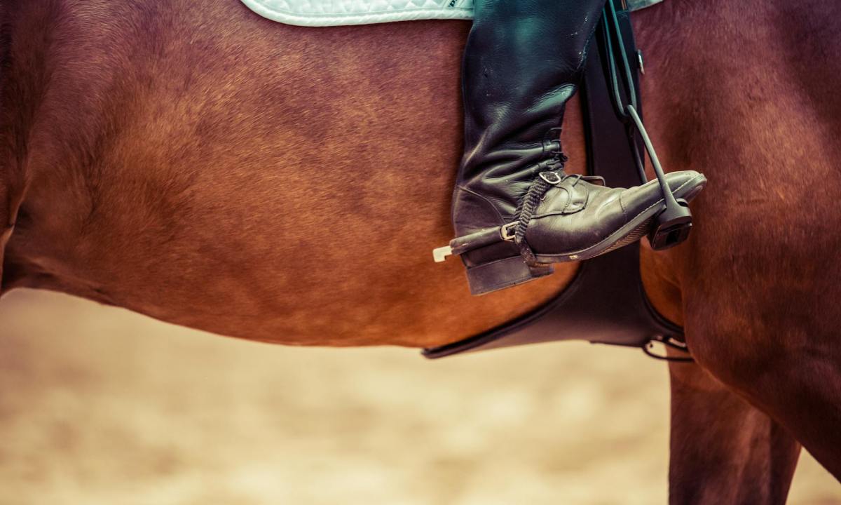 person wearing cowboy boots on horse