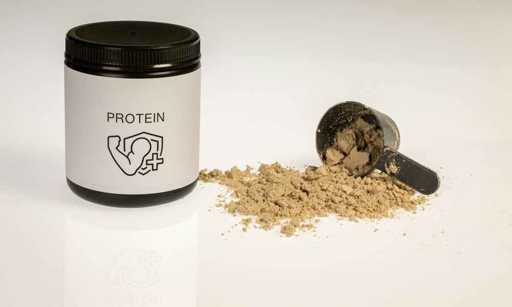 a jar of protein powder next to a scoop of protein powder