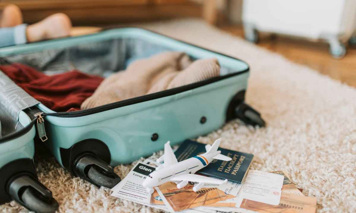 black and green suitcase on brown carpet