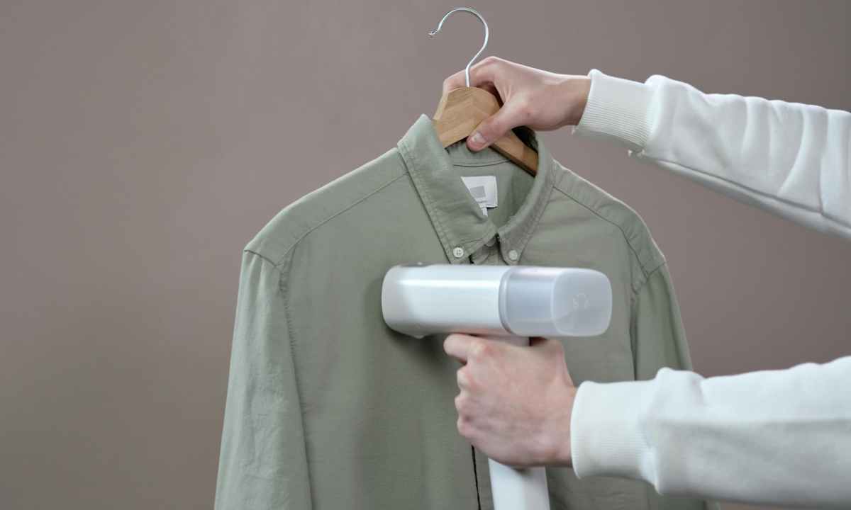 person steaming a button up shirt