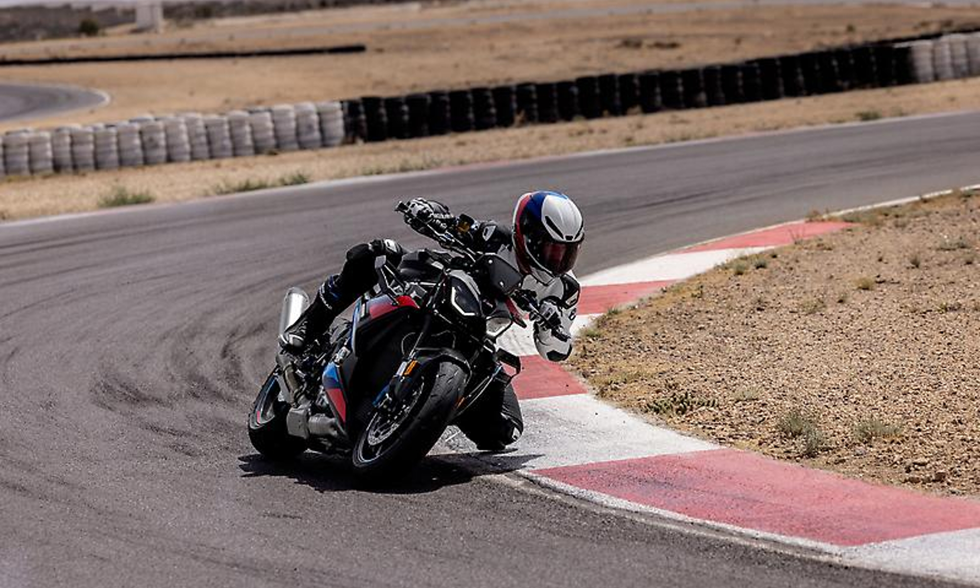 2025 BMW M 1000 R cornering deep on a race track.