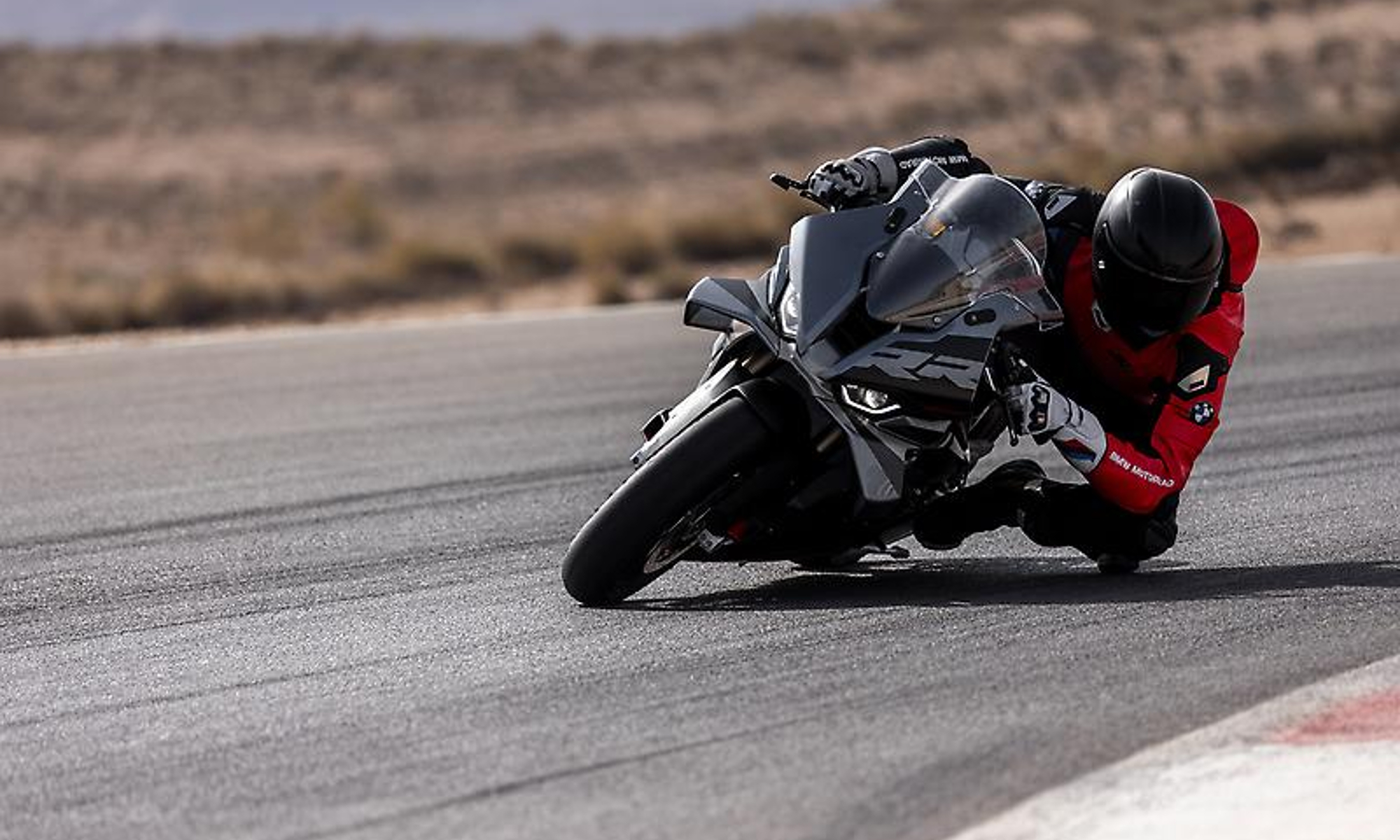 2025 BMW S 1000 RR in a deep corner on a race track.