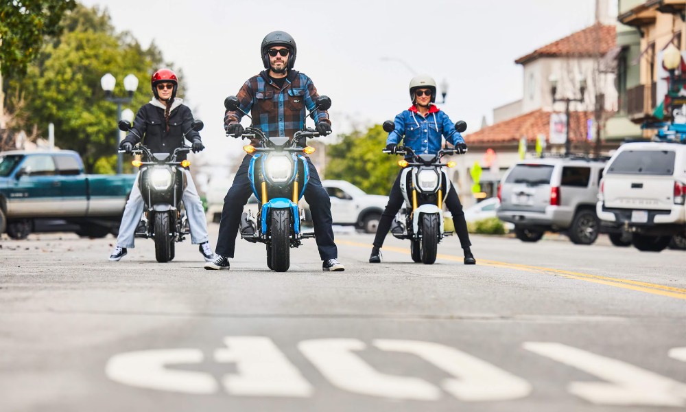 2025 Honda Grom three abreast in a city street.