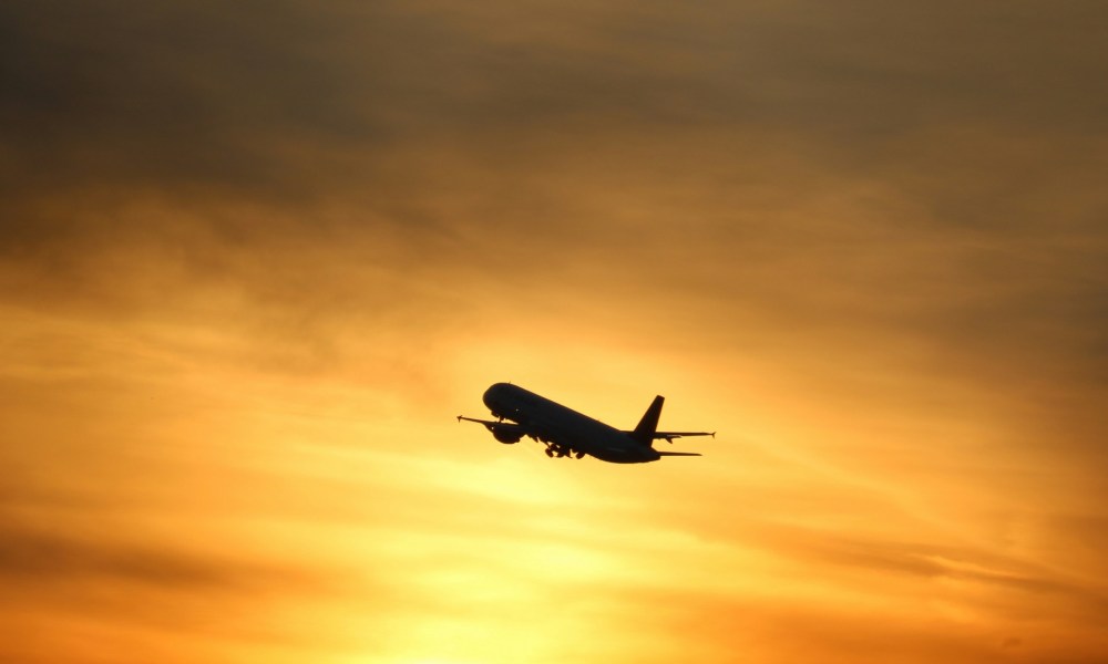 Airplane flying at sunset