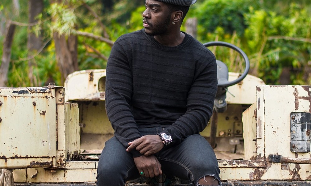 Man in black jeans, sweater, and hat