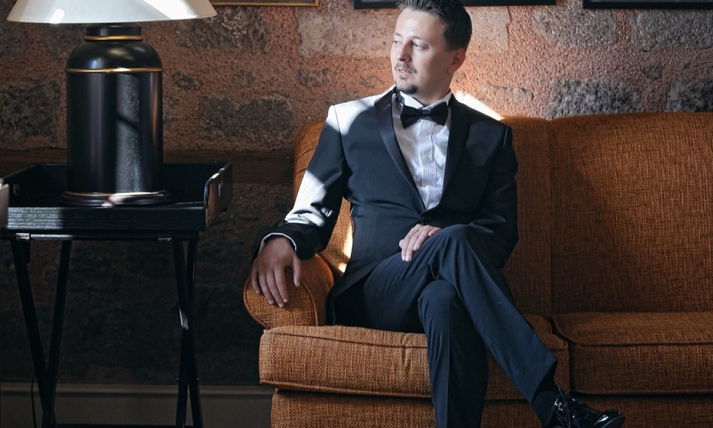 Man in a tux sitting on a couch