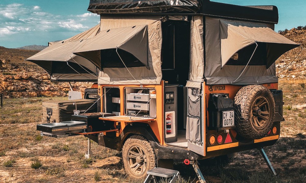 An Invader Duo X off-road travel trailer setup for camping in the desert.