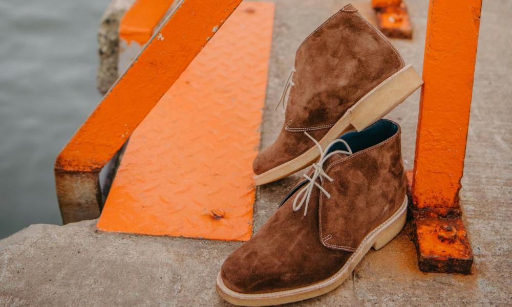 brown suede shoes sitting against concrete