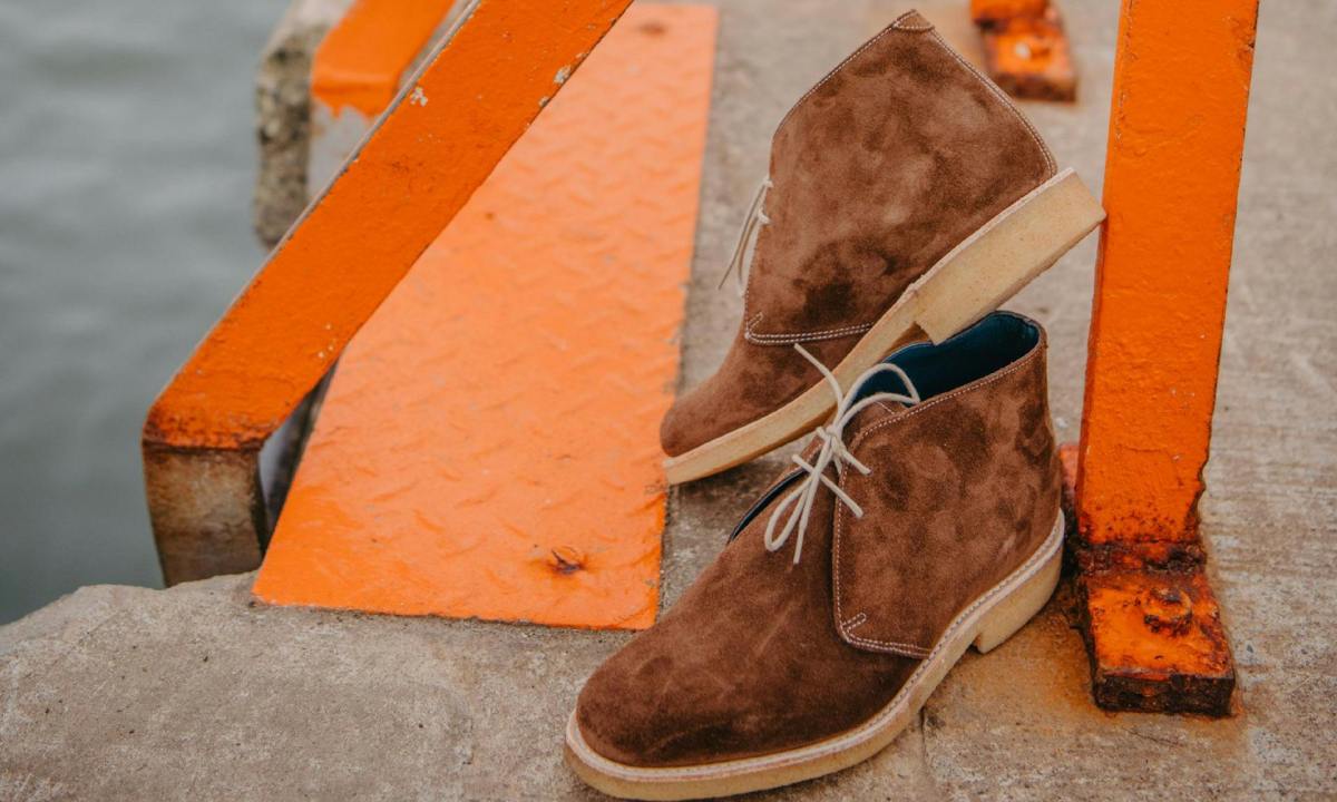 brown suede shoes sitting against concrete