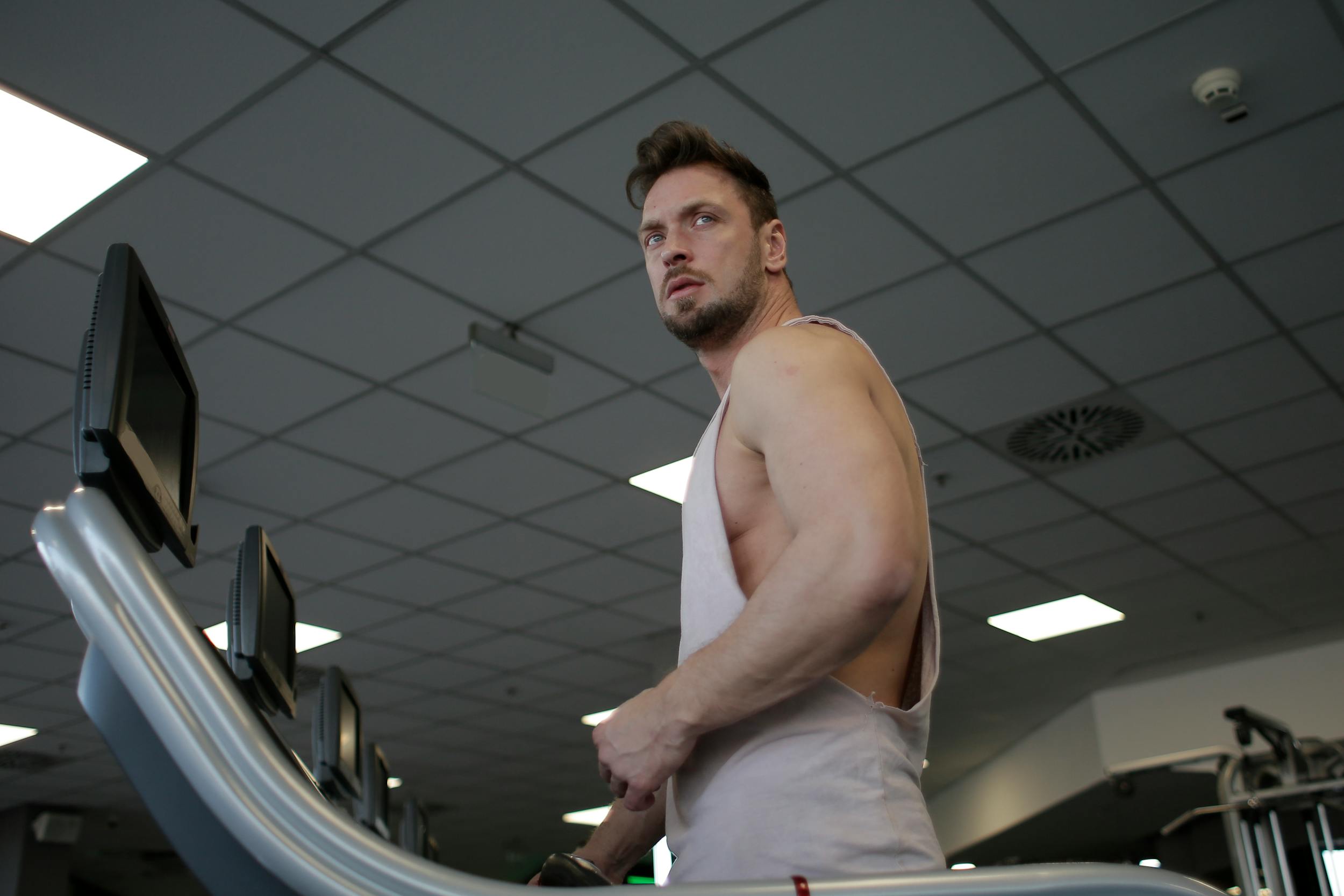 Man on treadmill with sleeveless shirt in gym