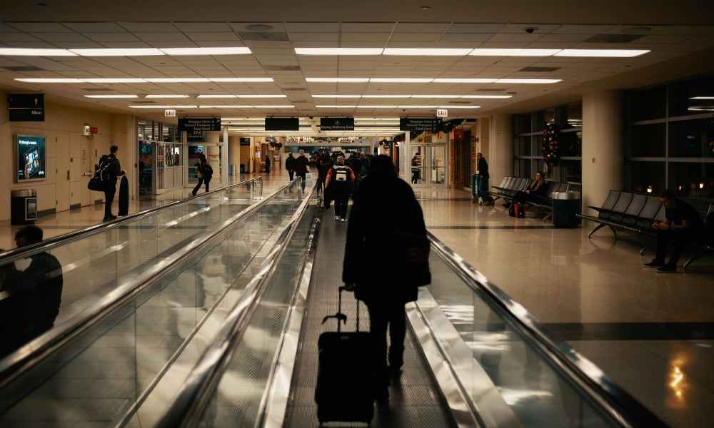 person rolling luggage through airport