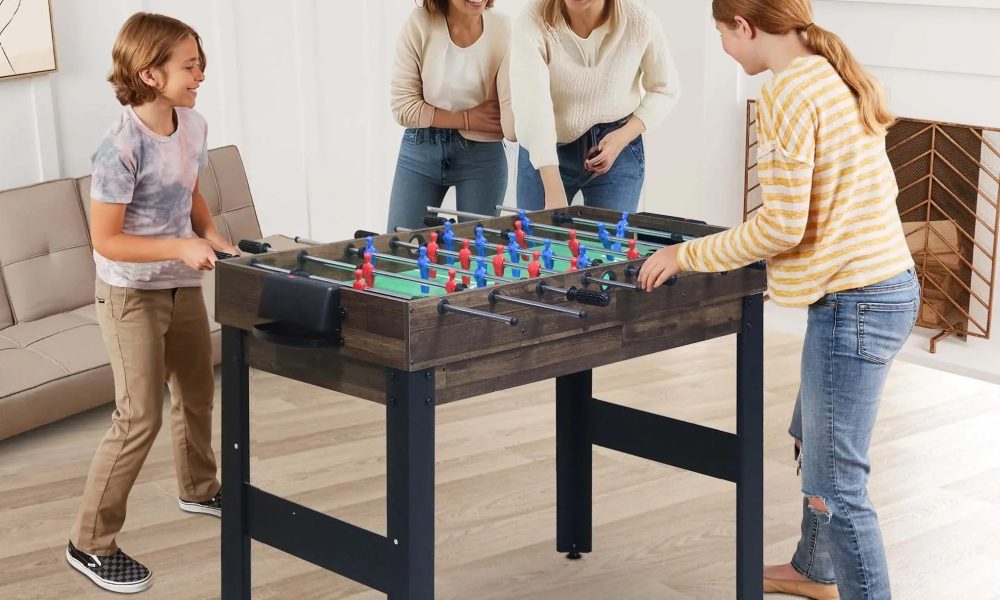 A family play's foosball on Segmart's 16-in-1 game table.