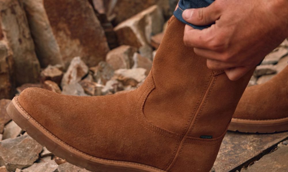 man pulling up brown boots