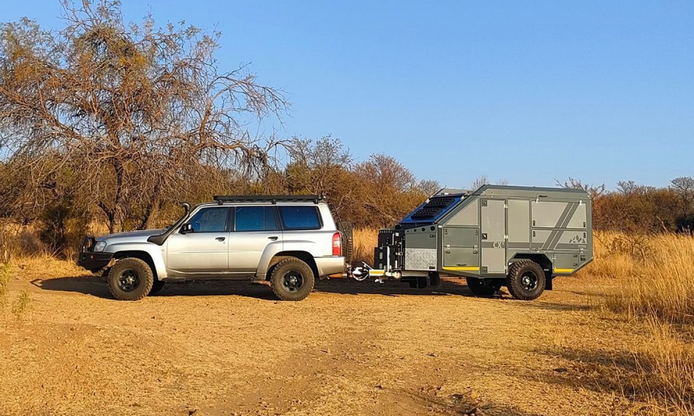 BERG Off-Road's new CX3 off-road travel trailer being towed by an SUV on a desert trail