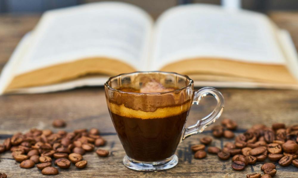 Espresso cup with a book and coffee beans