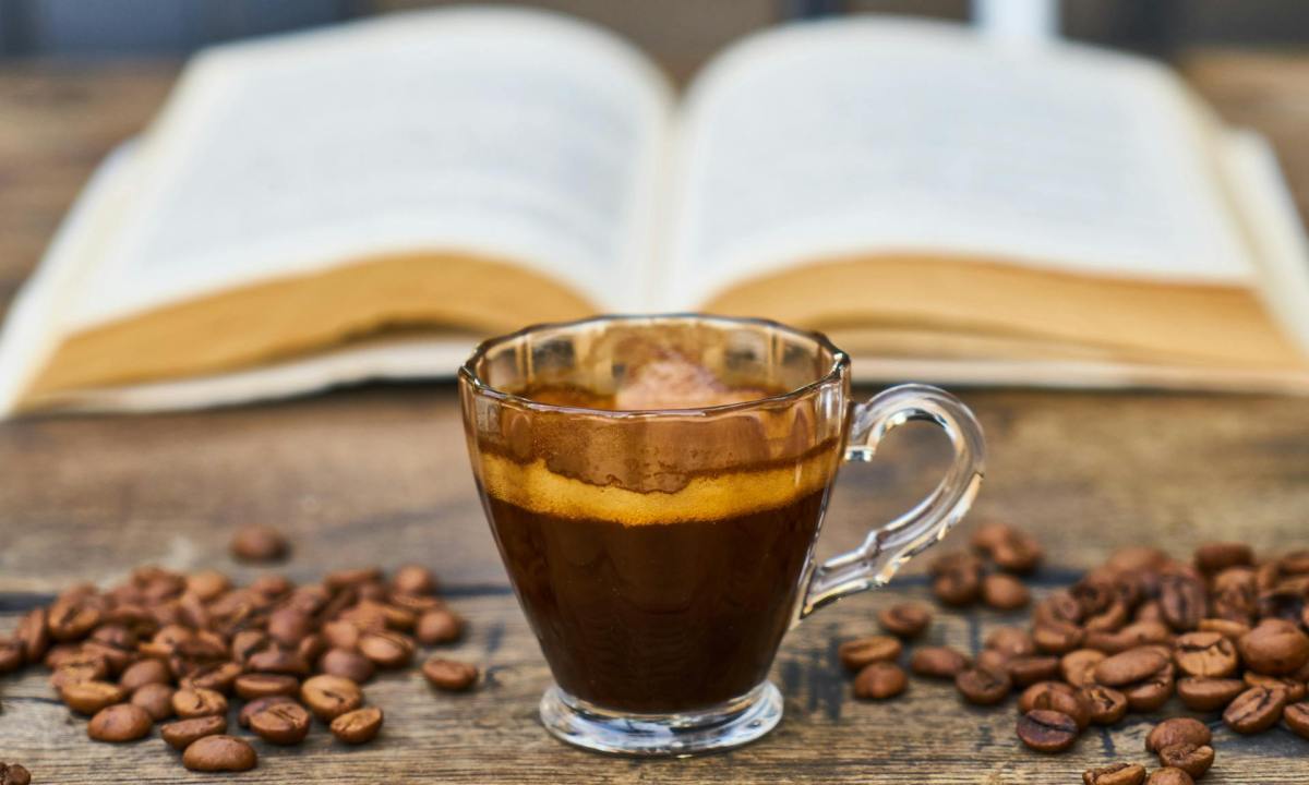 Espresso cup with a book and coffee beans