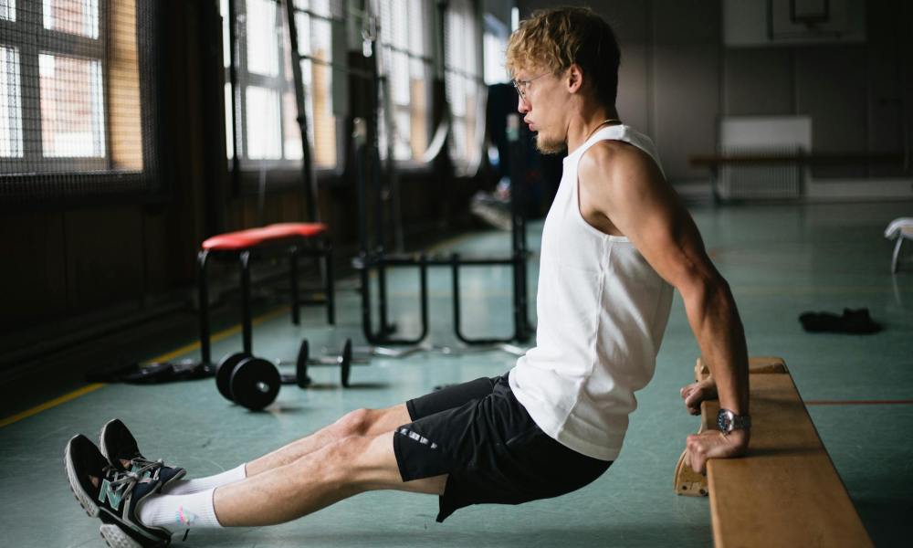 Man doing bench dip in gym