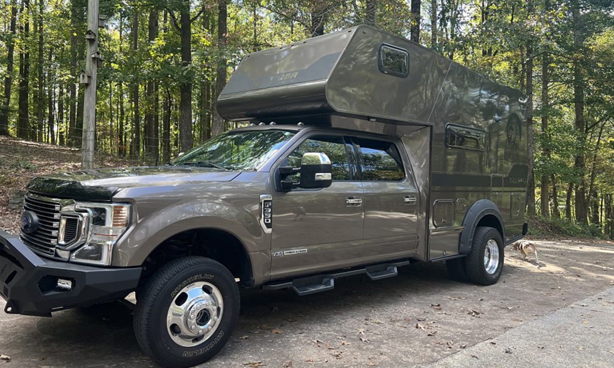 Tiger Adventure Vehicles' all-new Panthera off-road pickup truck camper parked on a wooded road.