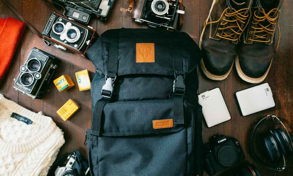 camera and accessories scattered around backpack