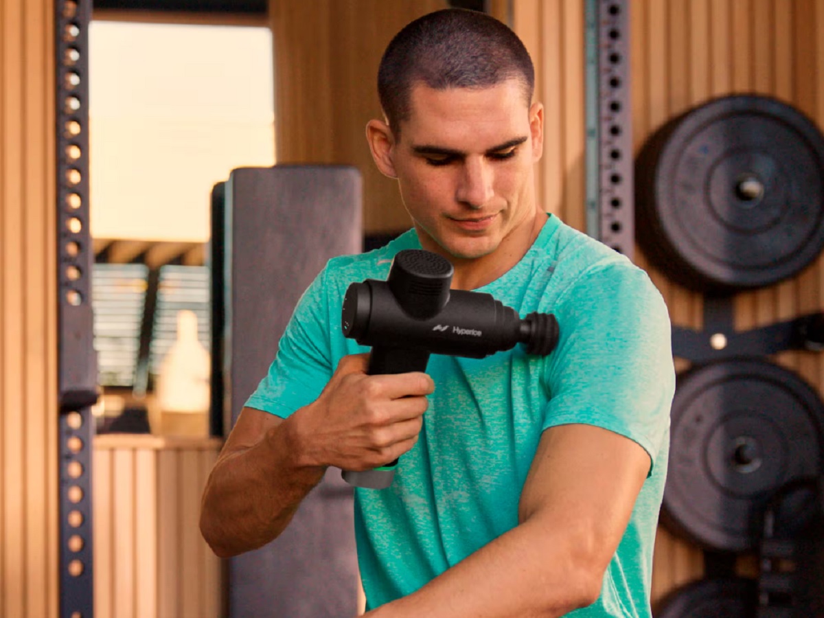 A man using the Hyperice Hypervolt 2 Pro Premium massage gun.