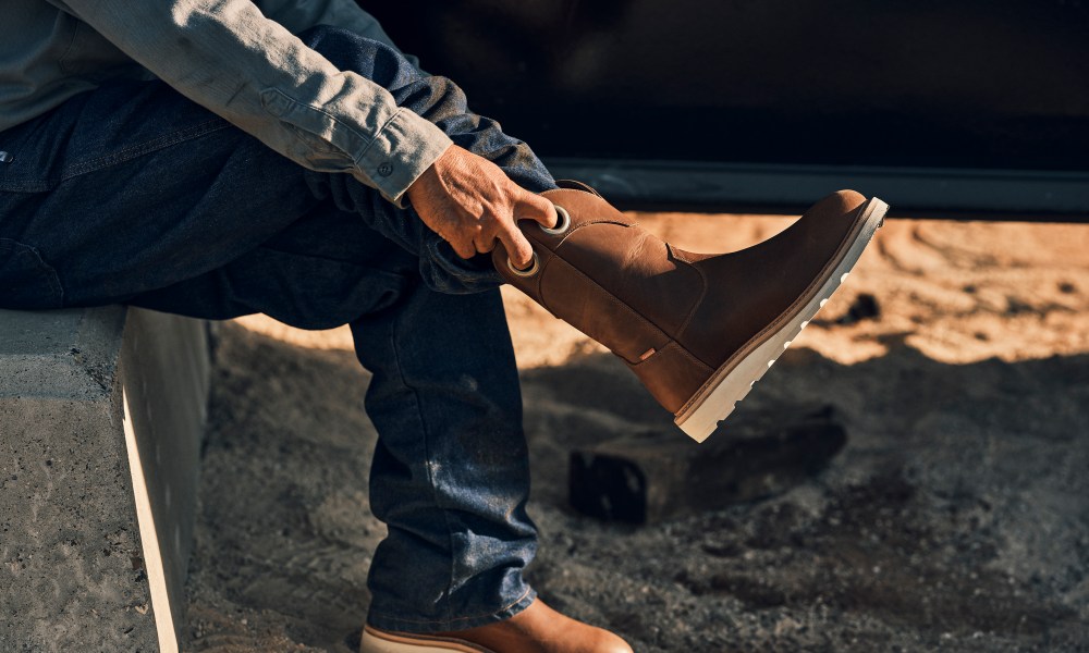 man putting on western work boots