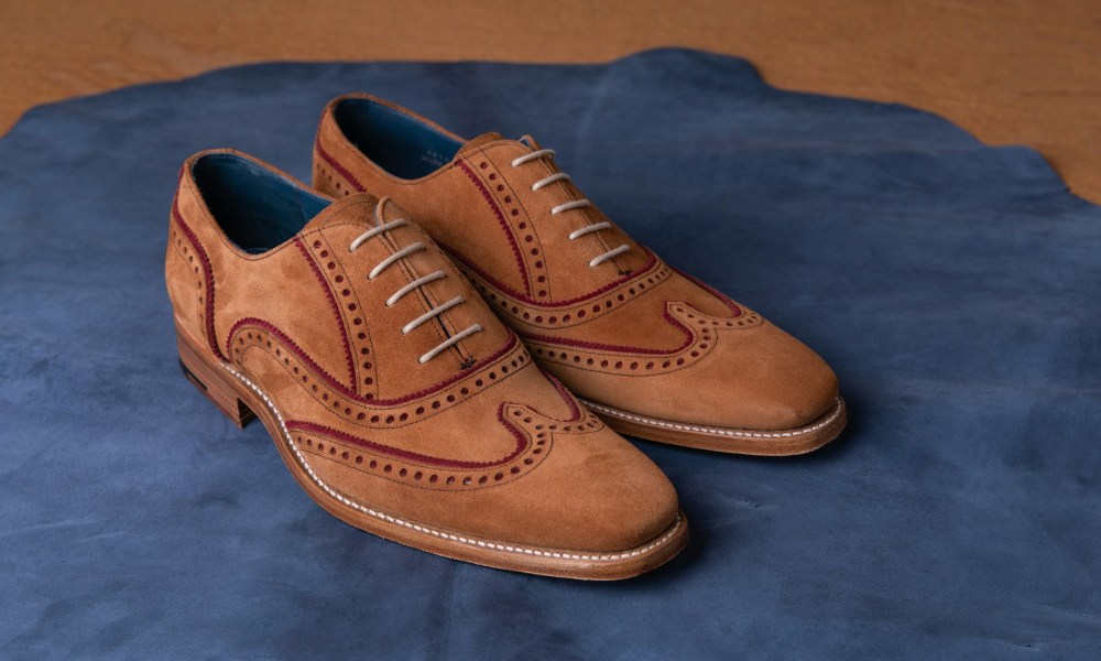 brown suede wingtip shoes on blue carpet