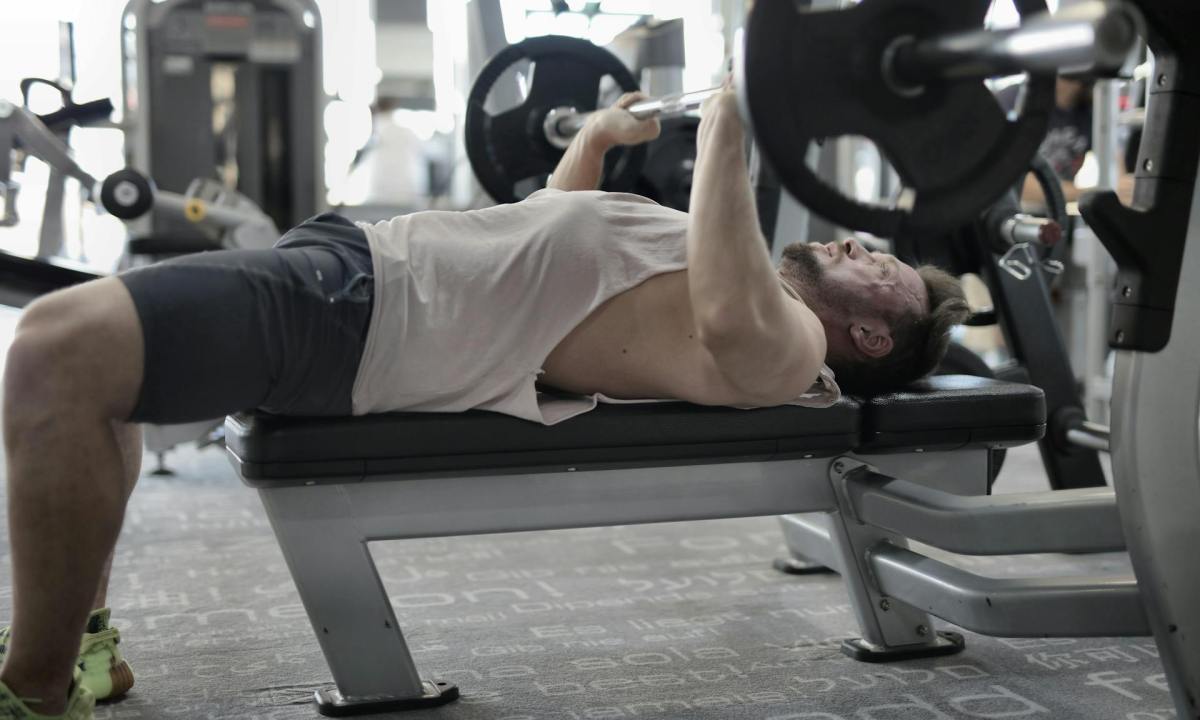 man doing bench press in gym resistance training