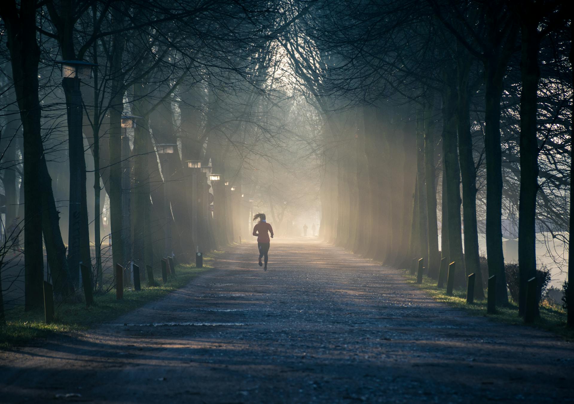 Woman running between trees