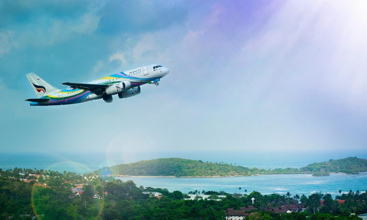 plane taking off with ocean in the background