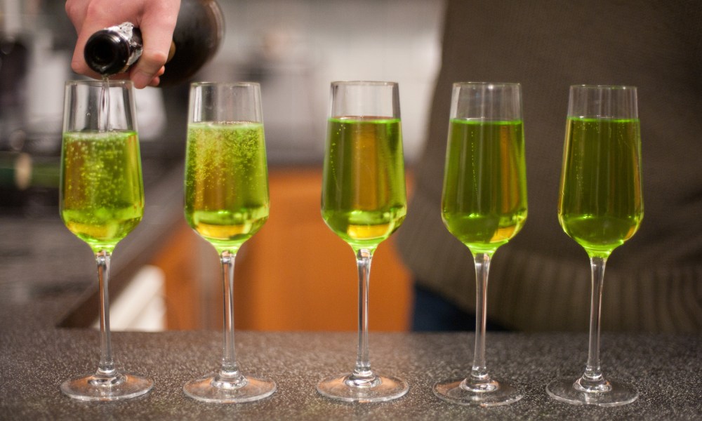 grinchmas cocktail a sparkling wine and green liqueur being poured