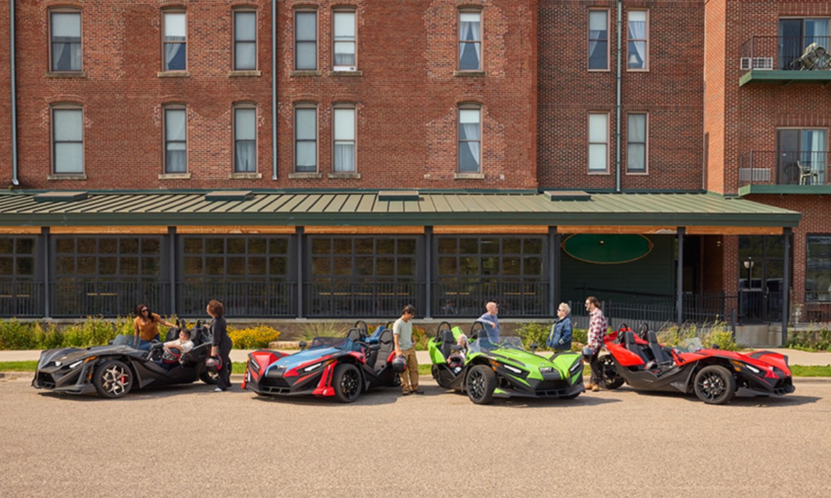 2025 Polaris Slingshot lienup parked in front of an apartment building, models S, SL, SLR, and R.